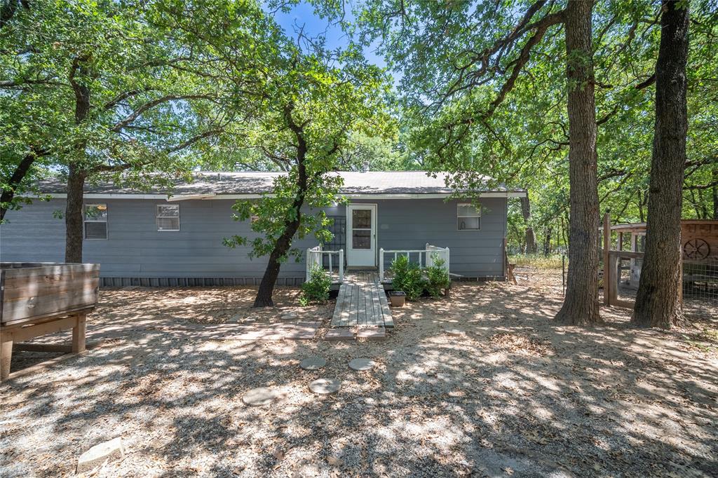 1285 Clark Road Gainesville, TX 76240 - Photo 13 of 20 The property features an exterior with blue siding, a white front door, and a small porch with white railings