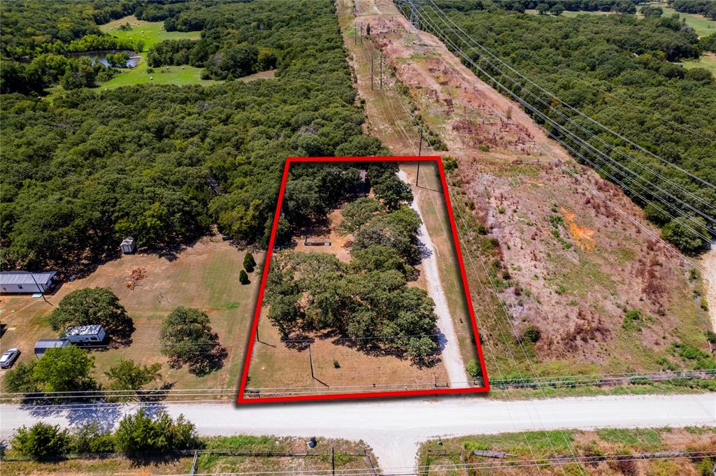 1285 Clark Road Gainesville, TX 76240 - Photo 19 of 20 Aerial view of the property, featuring a land lot with mature trees and a long driveway