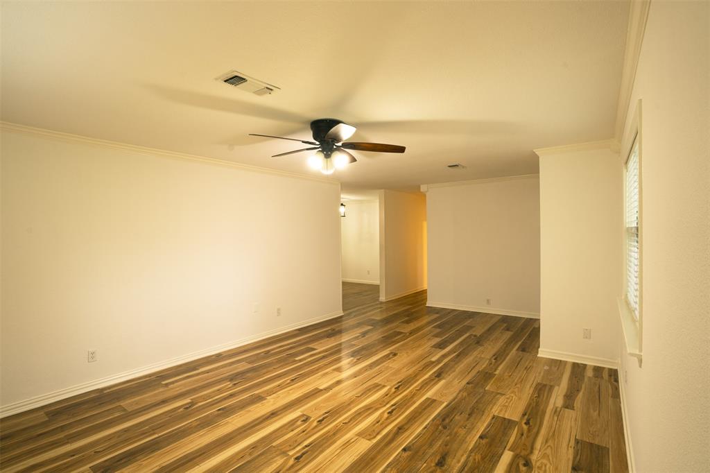 1285 Clark Road Gainesville, TX 76240 - Photo 6 of 20 The property features wood-style flooring, a ceiling fan with integrated lighting, and a window with blinds