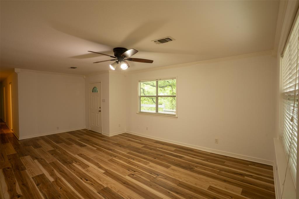 1285 Clark Road Gainesville, TX 76240 - Photo 7 of 20 The room features light wood flooring, white walls, and a ceiling fan with integrated lighting