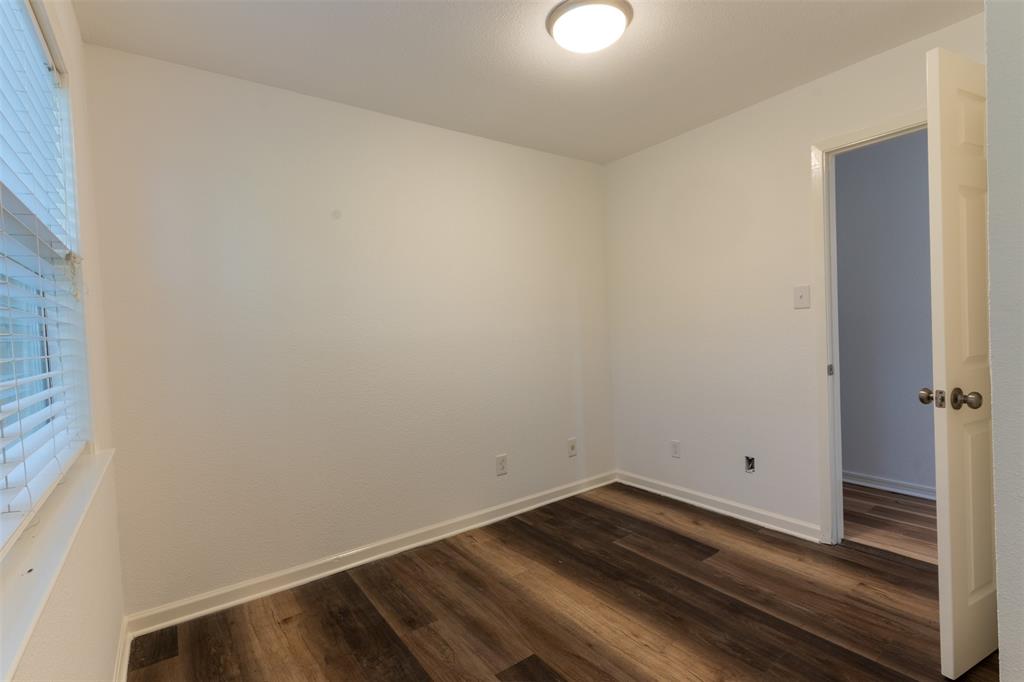 1285 Clark Road Gainesville, TX 76240 - Photo 8 of 20 The room features rich-toned hardwood flooring, white walls, and a window with horizontal blinds
