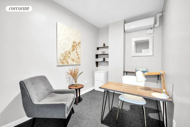 a view of a workspace with furniture and a window