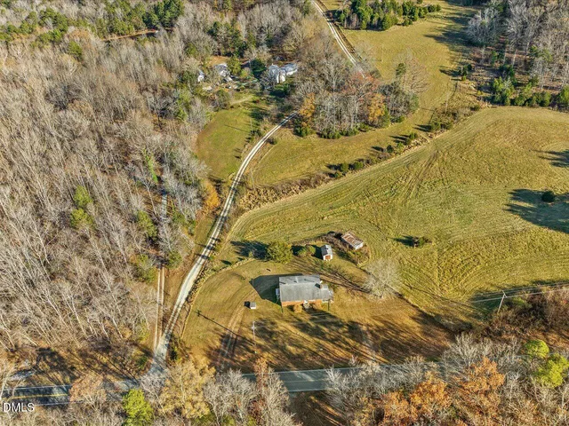 a view of an empty room with a window and a kitchen