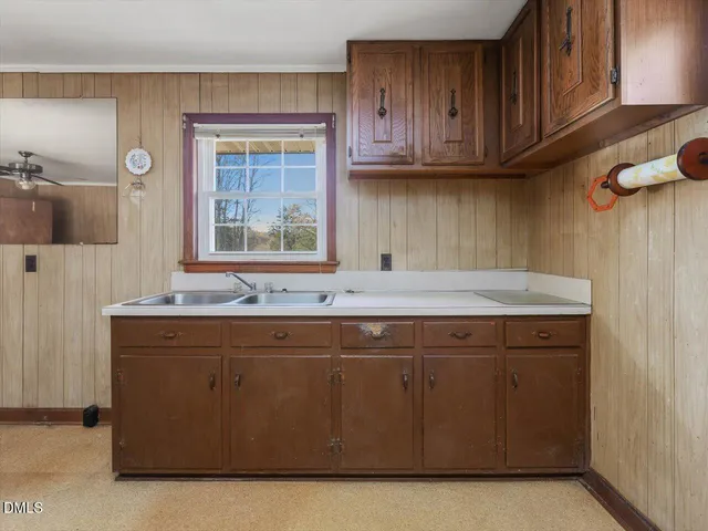 a view of an empty room with wooden floor and a ceiling fan