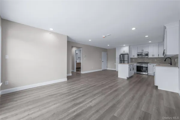 a view of empty room with wooden floor and entryway