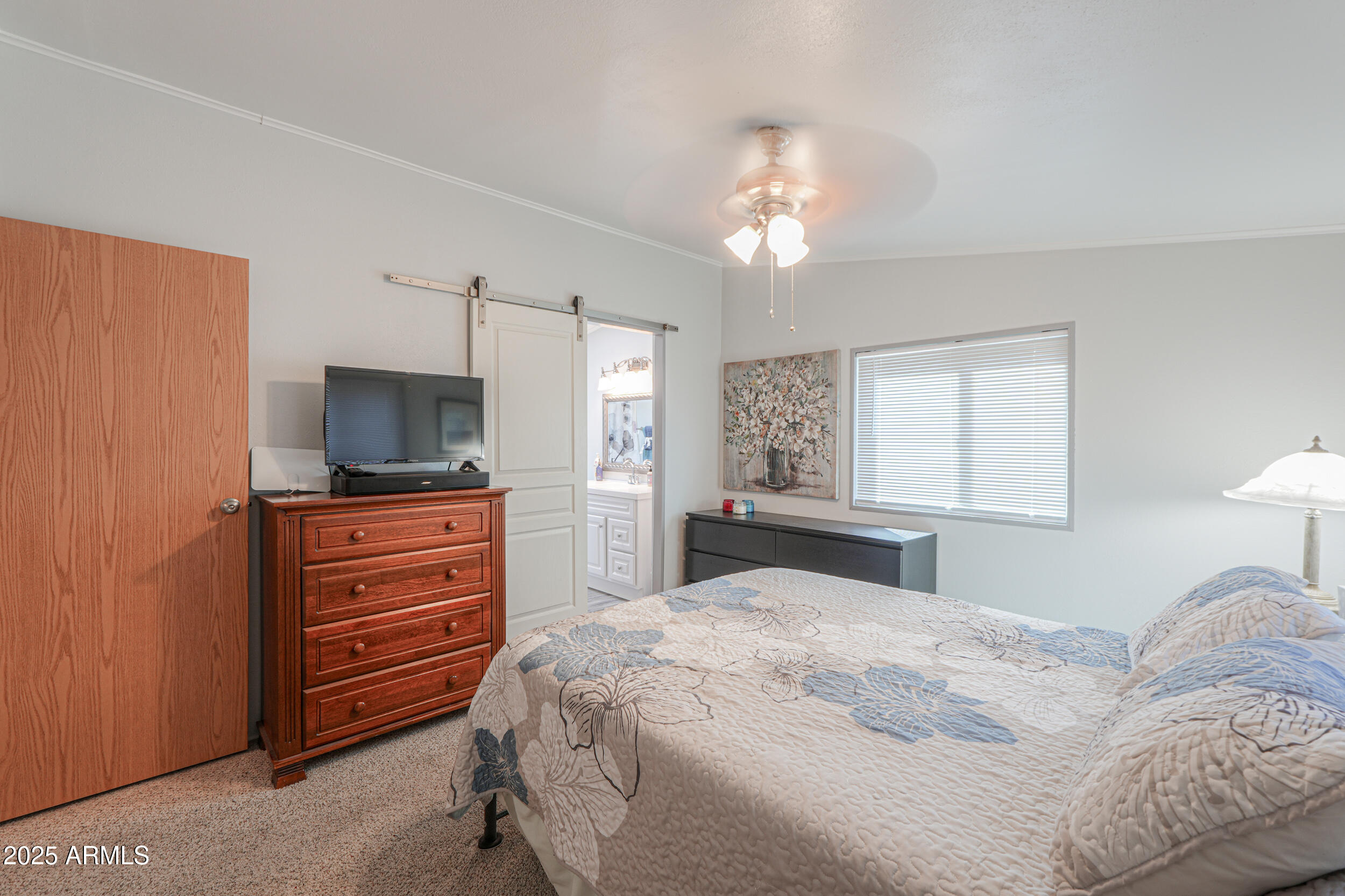2208 West Baseline Avenue, Unit 40 Apache Junction, AZ 85120 - Photo 12 of 30 a bedroom with a large bed and a flat tv screen on dresser