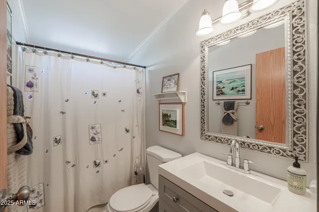 a bedroom with a bed and a flat tv screen on a dresser