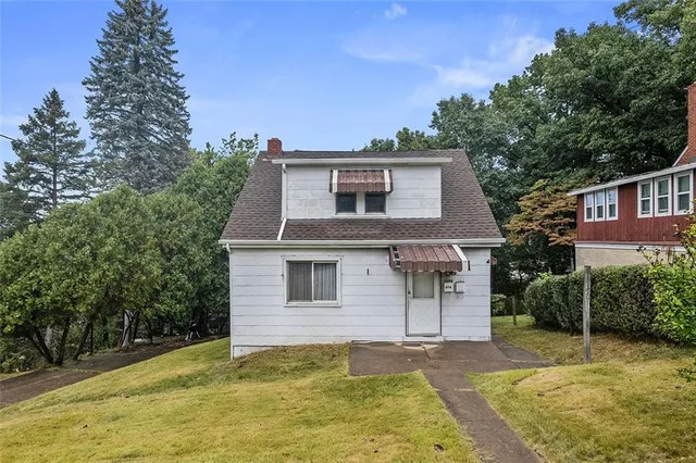 a front view of a house with a garden
