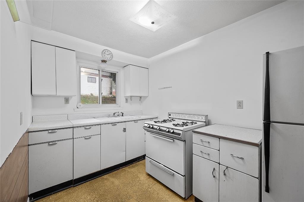 3708 Grant Street Pittsburgh, PA 15234 - Photo 22 of 36 a kitchen with granite countertop cabinets and white appliances