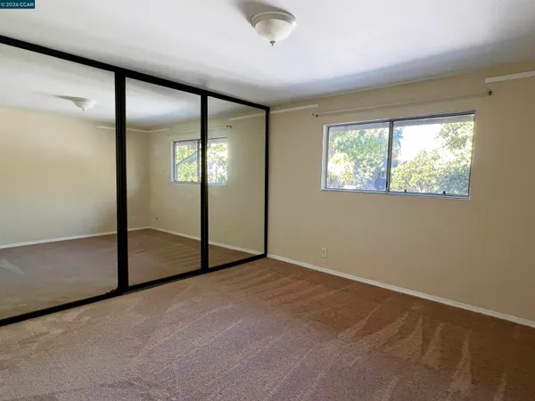 an empty room with windows and closet