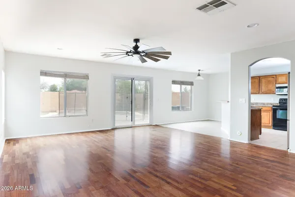 a view of an empty room with a window and wooden floor