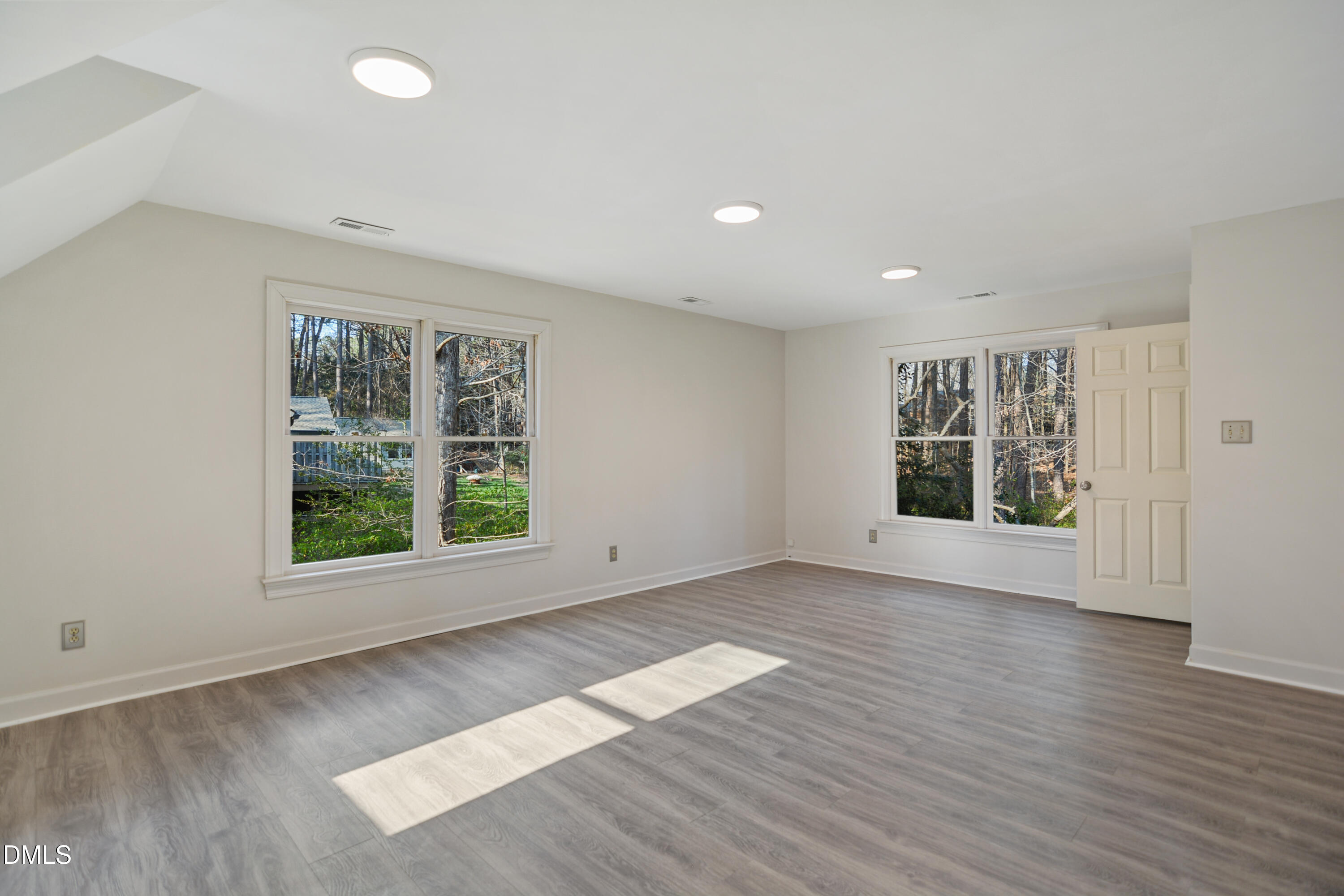 5008 Wood Valley Drive Raleigh, NC 27613 - Photo 23 of 37 an empty room with wooden floor and windows