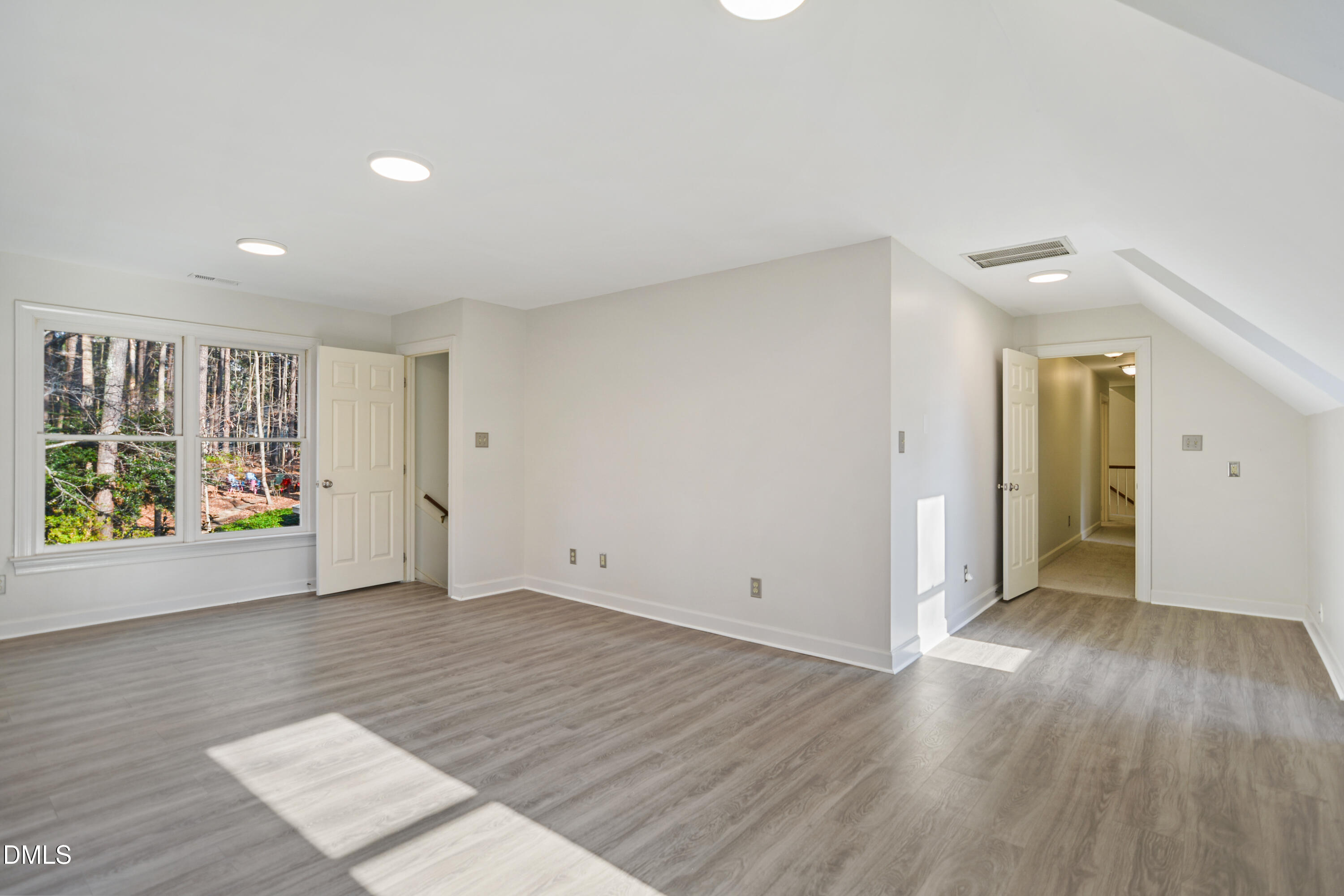5008 Wood Valley Drive Raleigh, NC 27613 - Photo 24 of 37 an empty room with wooden floor and windows