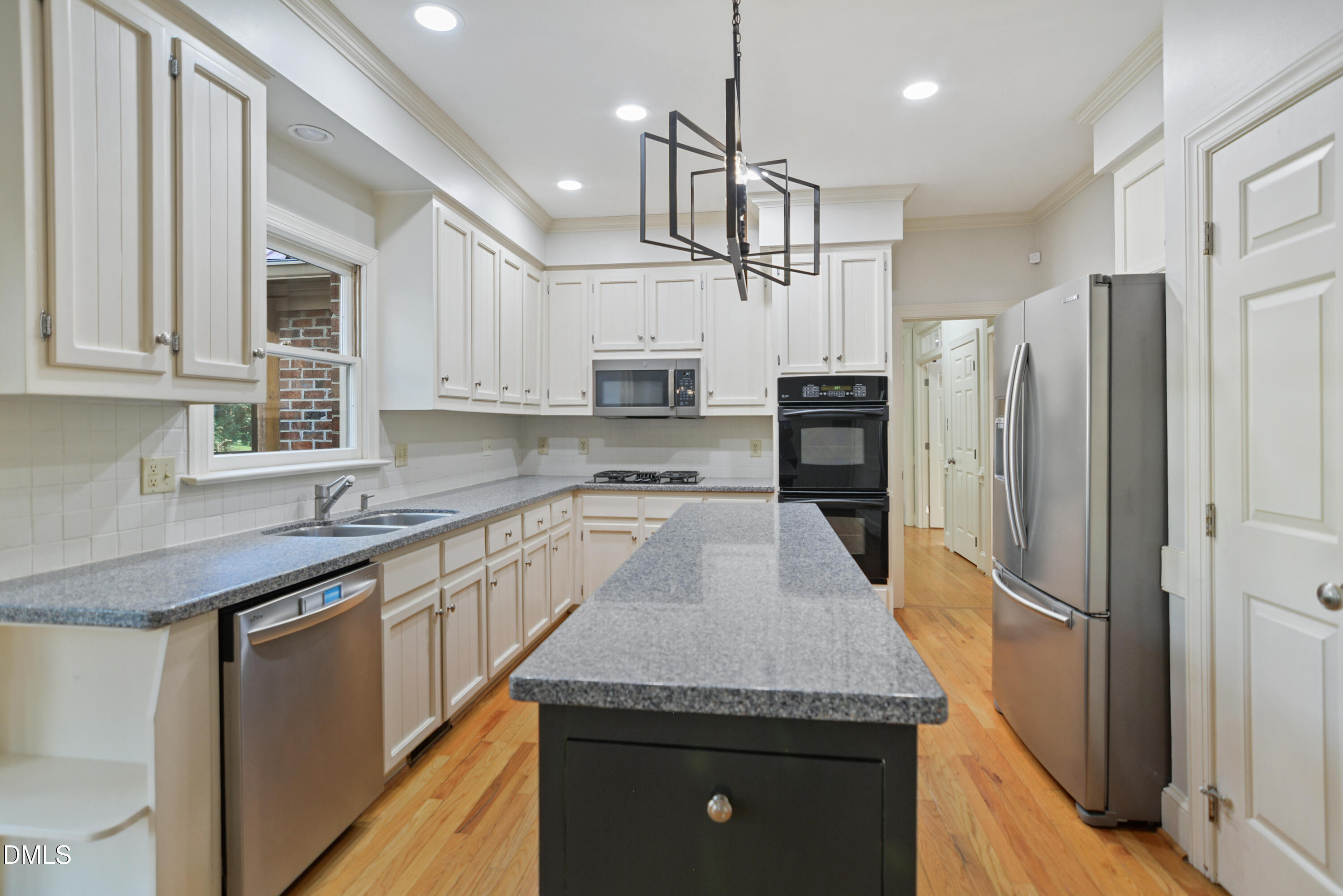 5008 Wood Valley Drive Raleigh, NC 27613 - Photo 9 of 37 a kitchen with stainless steel appliances granite countertop a sink refrigerator and microwave