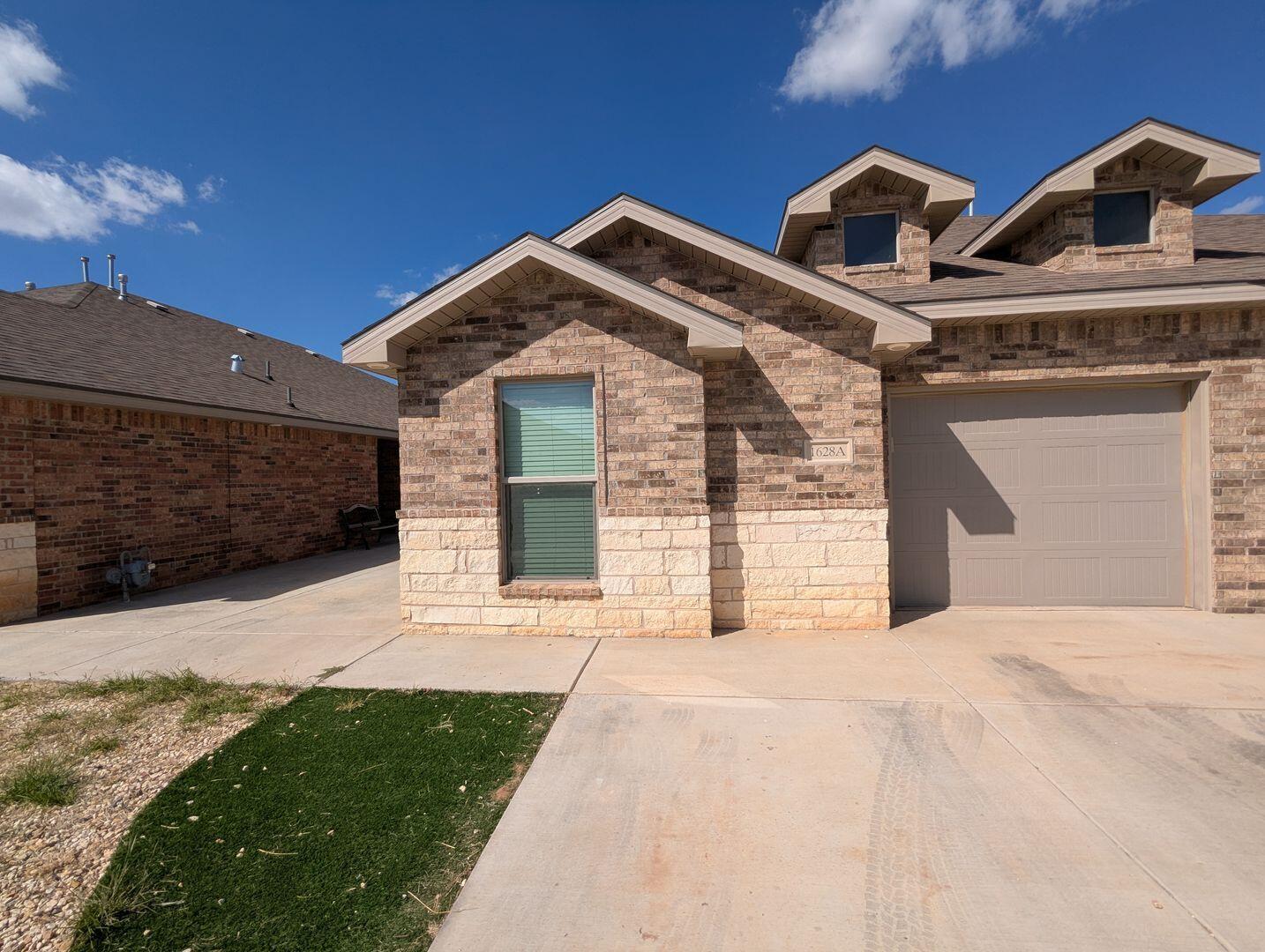 1628 133rd Street, Unit A Lubbock, TX 79423 - Photo 1 of 11 a front view of a house with a yard