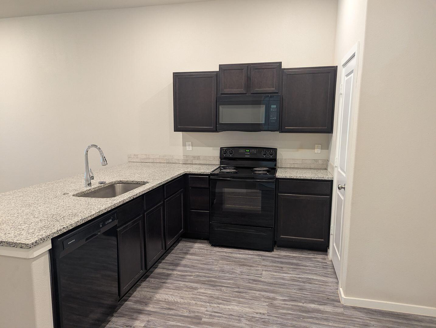1628 133rd Street, Unit A Lubbock, TX 79423 - Photo 5 of 11 a kitchen with stainless steel appliances granite countertop a sink and a stove
