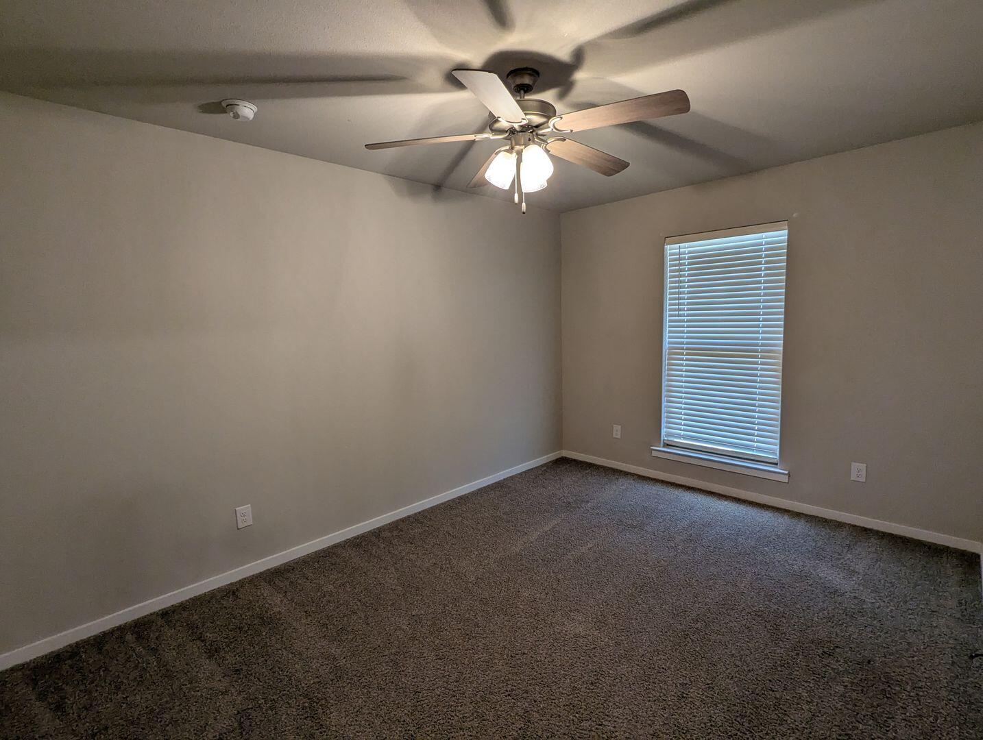 1628 133rd Street, Unit A Lubbock, TX 79423 - Photo 6 of 11 en empty room with windows and fan