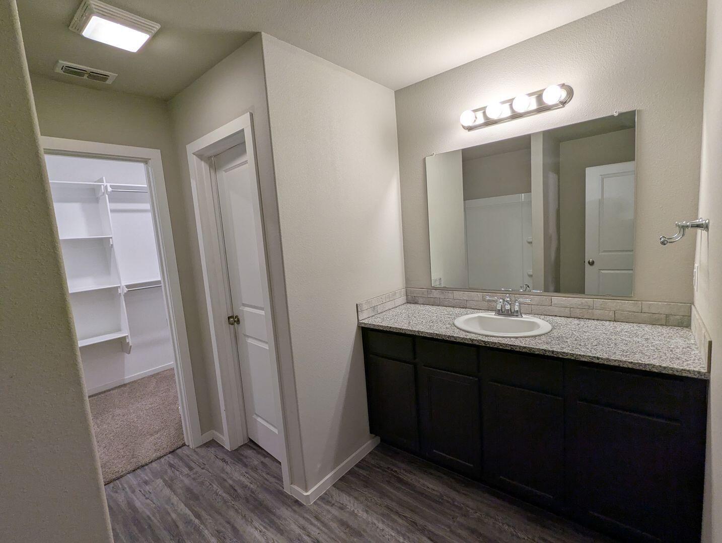 1628 133rd Street, Unit A Lubbock, TX 79423 - Photo 7 of 11 a bathroom with a double vanity sink and mirror