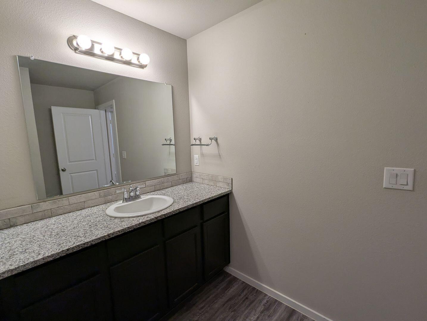 1628 133rd Street, Unit A Lubbock, TX 79423 - Photo 9 of 11 a bathroom with a sink and a mirror