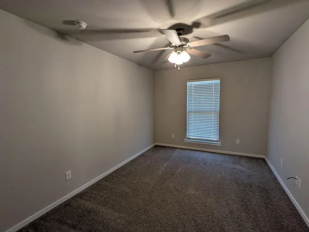 en empty room with windows and fan