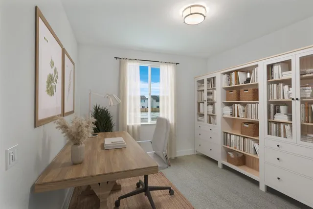a view of a workspace with furniture and a book shelf