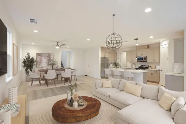 a living room with furniture a chandelier and a view of kitchen