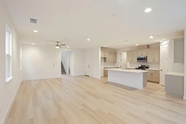 a view of kitchen with kitchen island white cabinets and wooden floor