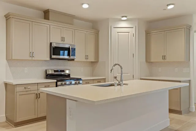 a kitchen with stainless steel appliances a sink a stove a microwave and cabinets