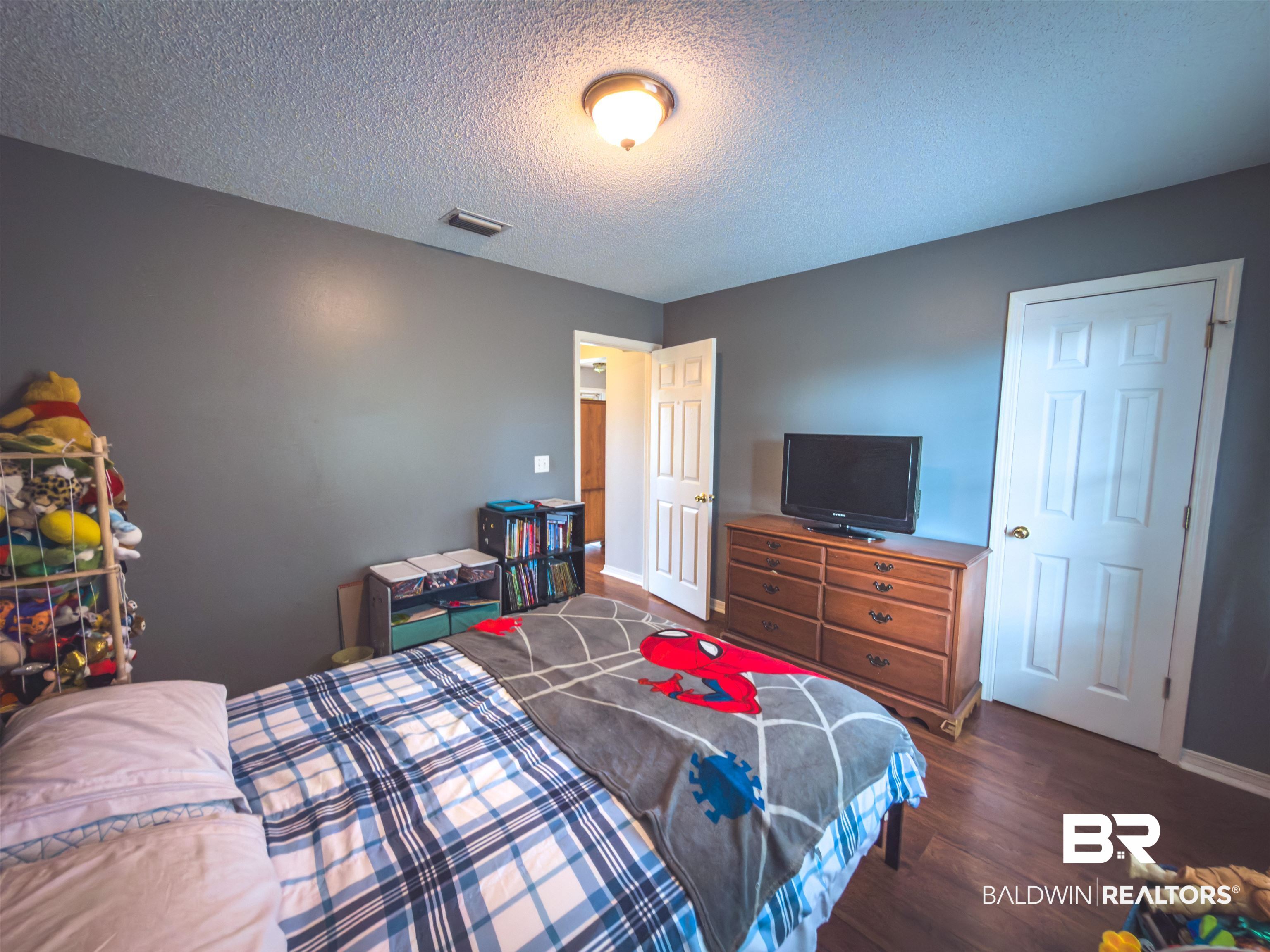 129 Pennbrooke Loop Foley, AL 36535 - Photo 18 of 44 Bedroom featuring dark wood finished floors and a textured ceiling