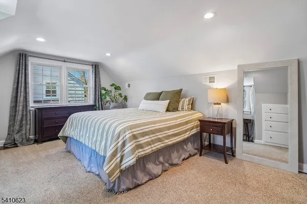 a spacious bedroom with a bed and dresser