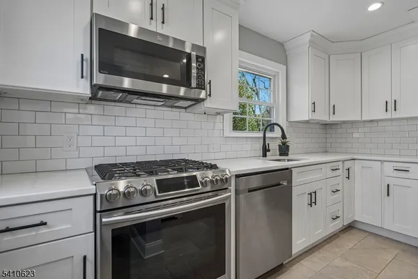 a kitchen with cabinets stainless steel appliances and a sink