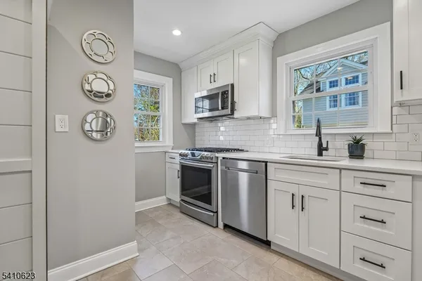 a kitchen with stainless steel appliances granite countertop a sink and a stove top oven