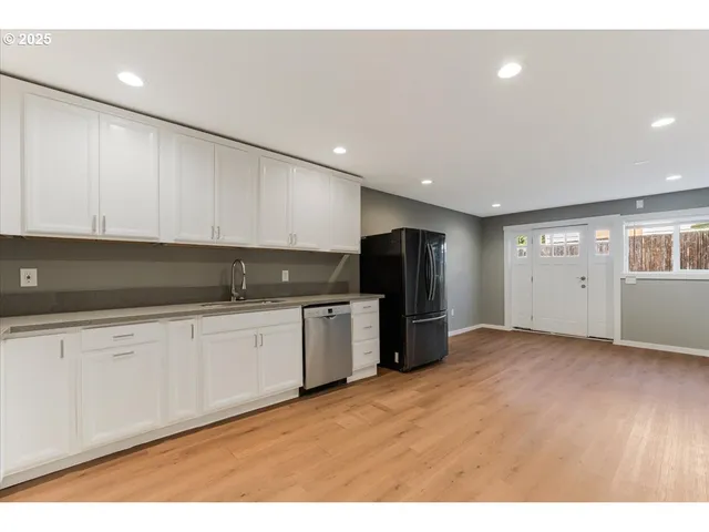 a kitchen with stainless steel appliances granite countertop a refrigerator a sink and a stove