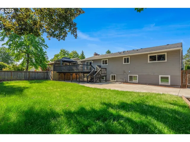 a view of a backyard with table and chairs potted plants and wooden fence