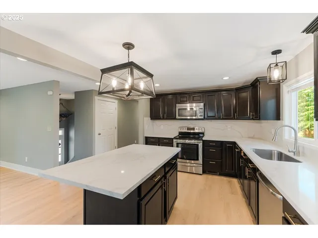 a kitchen with cabinets and wooden floor