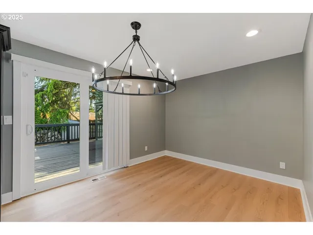a view of empty room with wooden floor and floor to ceiling window