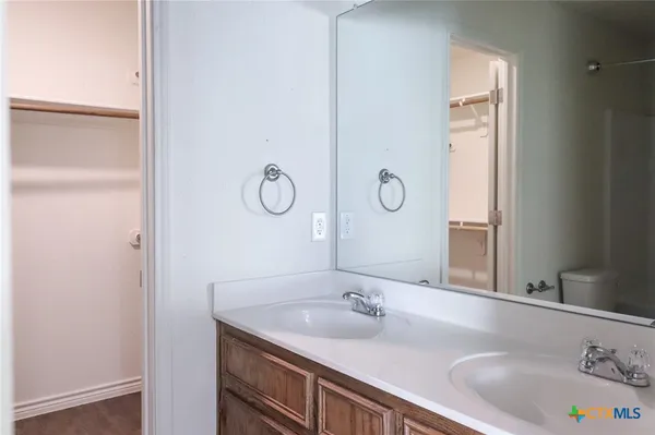 an empty room with wooden floor fan and window