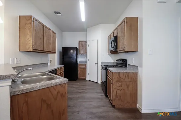 a kitchen with stainless steel appliances granite countertop a refrigerator stove and microwave