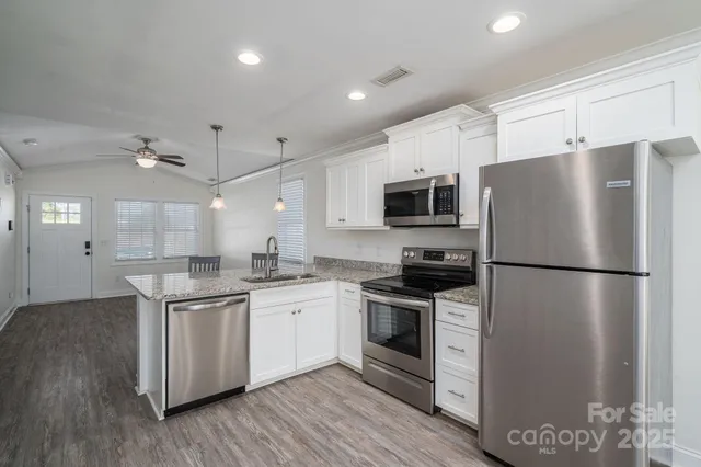 a kitchen with stainless steel appliances a refrigerator sink and microwave