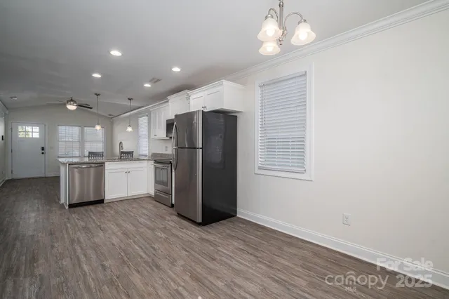 a kitchen with stainless steel appliances kitchen island a refrigerator sink and cabinets
