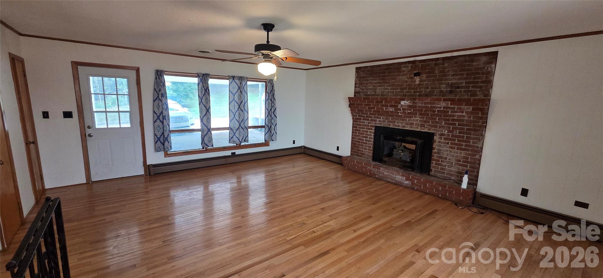 214 Old Dale Road Spruce Pine, NC 28777 - Photo 19 of 39 a view of an empty room with wooden floor fireplace and a window