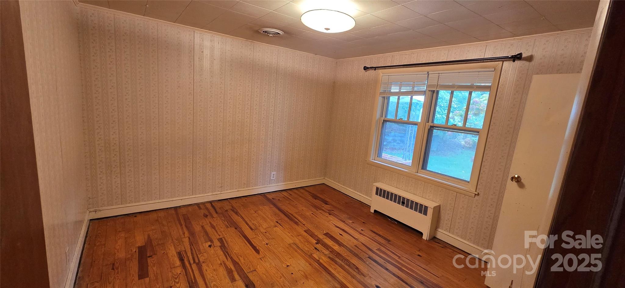 214 Old Dale Road Spruce Pine, NC 28777 - Photo 23 of 42 a view of an empty room with wooden floor and a window