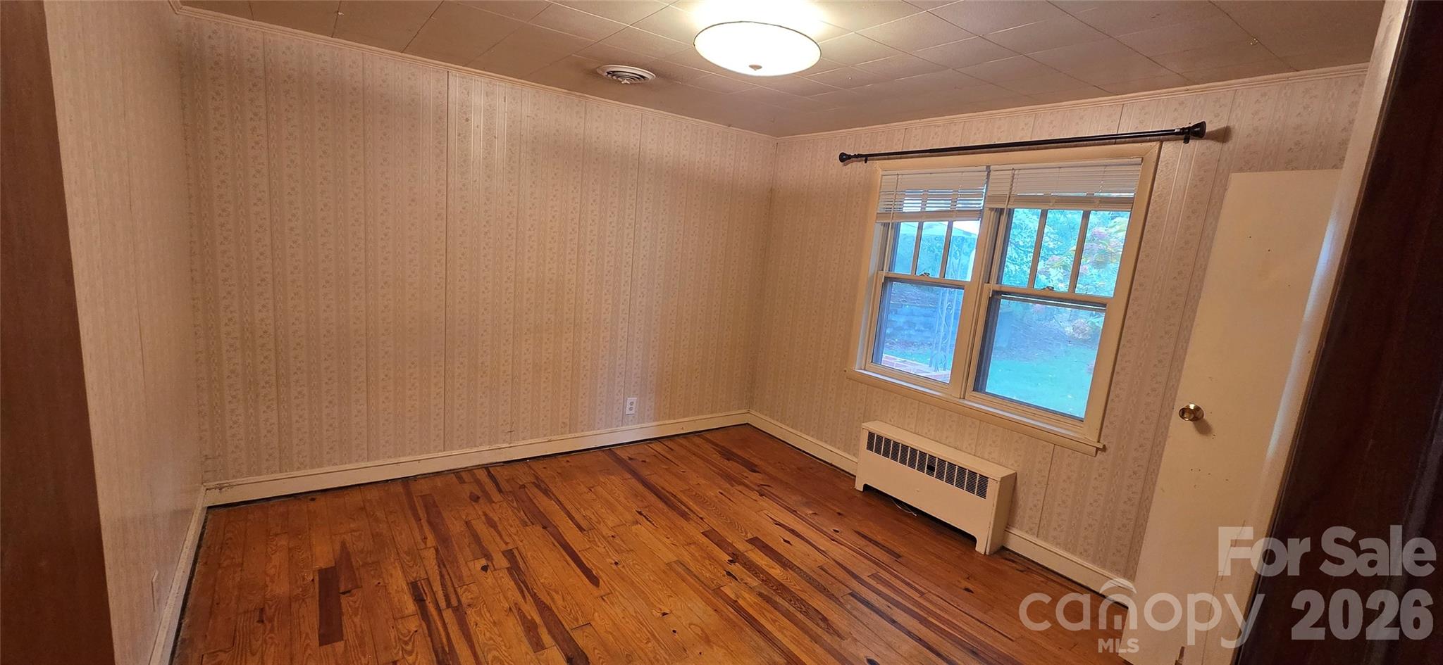 214 Old Dale Road Spruce Pine, NC 28777 - Photo 23 of 39 a view of an empty room with wooden floor and a window