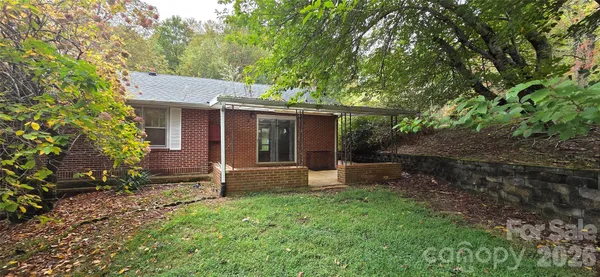 a front view of a house with a yard and trees
