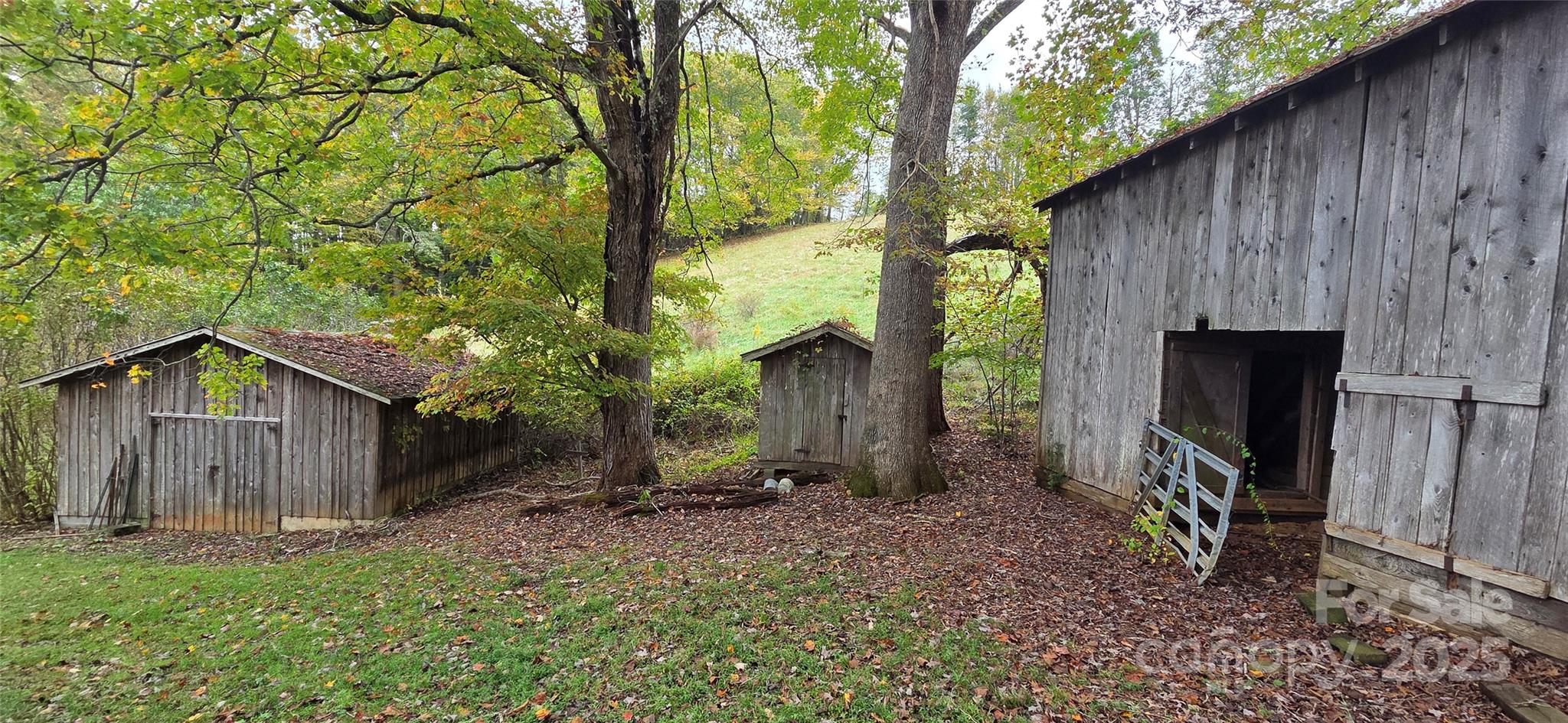 214 Old Dale Road Spruce Pine, NC 28777 - Photo 8 of 42 a view of a wooden house with a large tree and wooden fence