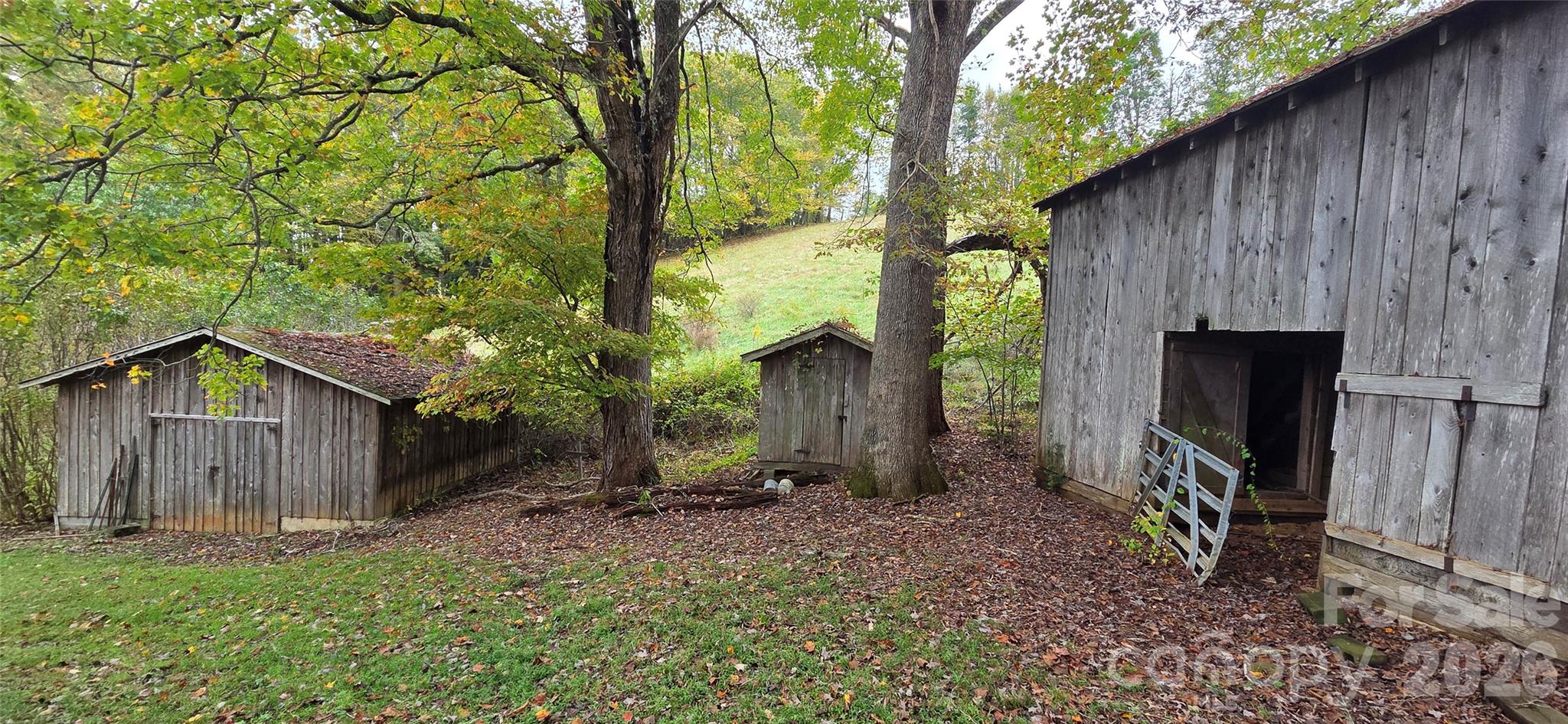 214 Old Dale Road Spruce Pine, NC 28777 - Photo 8 of 39 a view of a wooden house with a large tree and wooden fence