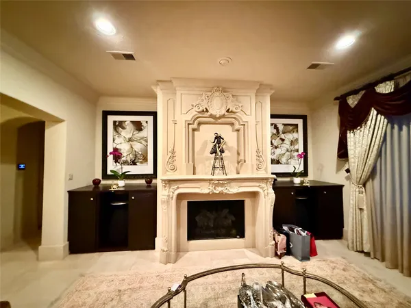 a living room with stainless steel appliances furniture a fireplace and a open kitchen view