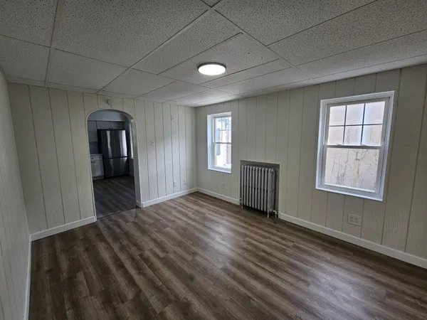 a view of empty room with wooden floor and window