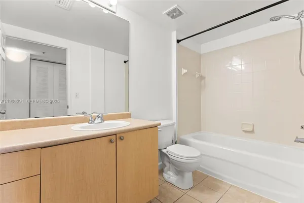 an empty room with windows and ceiling fan