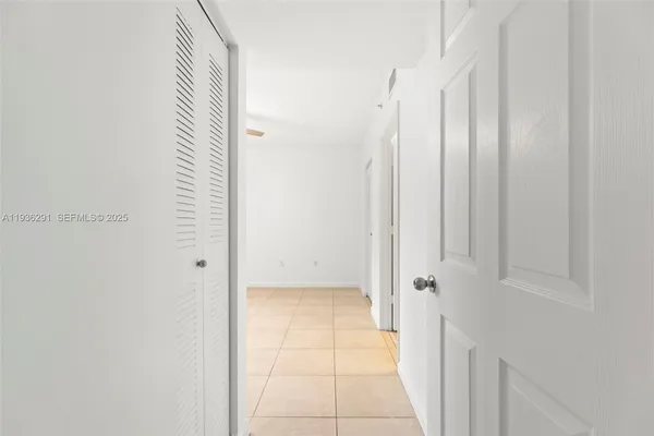 an empty room with windows and ceiling fan